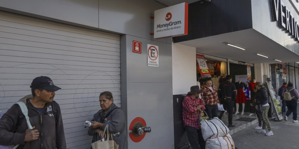 MEX3188. TIJUANA (MÉXICO), 17/02/2025.- Personas esperan frente a un establecimiento de envío de dinero este lunes, en Tijuana (México). El temor a las deportaciones masivas del presidente de Estados Unidos, Donald Trump, y las redadas han propiciado un incremento en el envío de remesas a la frontera norte de México, informó este lunes Sergio Vázquez, presidente del Colegio de Contadores Públicos de Tijuana. EFE/ Joebeth Terríquez