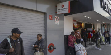 MEX3188. TIJUANA (MÉXICO), 17/02/2025.- Personas esperan frente a un establecimiento de envío de dinero este lunes, en Tijuana (México). El temor a las deportaciones masivas del presidente de Estados Unidos, Donald Trump, y las redadas han propiciado un incremento en el envío de remesas a la frontera norte de México, informó este lunes Sergio Vázquez, presidente del Colegio de Contadores Públicos de Tijuana. EFE/ Joebeth Terríquez