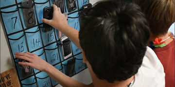 Minerva High School students grab their cellphones on the way out the door at the end of teacher Julie Holderbaum's English class. (CantonRep.com / Ray Stewart)