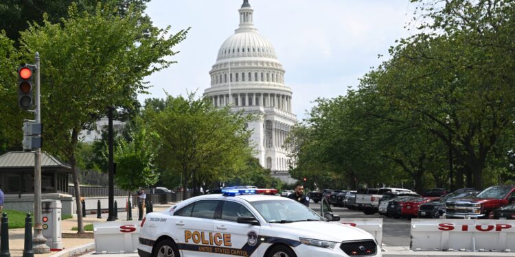 A US Capitol police officer stands by his car outside the Russell Senate Office Building in Washington, DC, on August 2, 2023, after unconfirmed eports of an active shooter in the building near the US Capitol. (Photo by SAUL LOEB / AFP)