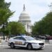 A US Capitol police officer stands by his car outside the Russell Senate Office Building in Washington, DC, on August 2, 2023, after unconfirmed eports of an active shooter in the building near the US Capitol. (Photo by SAUL LOEB / AFP)