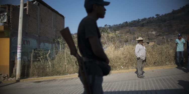 A Guerrero Community Police member stands guard in Tlacotepec, Heliodoro Castillo municipality, Guerrero state, Mexico, on March 24, 2018. - In the mountainous area of Guerrero state, one of the poorest and the most violent of Mexico, almost 7,000 people have taken the fight against organized crime as a personal cause making up a "community police". Urged by their daily life conflicts with criminal groups and the lack of answers from the government, these self-made-soldiers take up arms while they dream of peace. (Photo by Pedro PARDO / AFP) / TO GO WITH AFP STORY by Yussel GONZALEZ