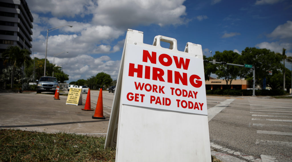A "Now Hiring" sign advertising jobs at a hand car wash is seen along a street, as the spread of the coronavirus disease (COVID-19) continues, in Miami, Florida, U.S. May 8, 2020. REUTERS/Marco Bello