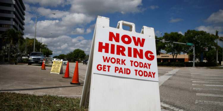 A "Now Hiring" sign advertising jobs at a hand car wash is seen along a street, as the spread of the coronavirus disease (COVID-19) continues, in Miami, Florida, U.S. May 8, 2020. REUTERS/Marco Bello