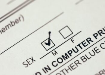 Person checking the male gender box on a document form with black pen