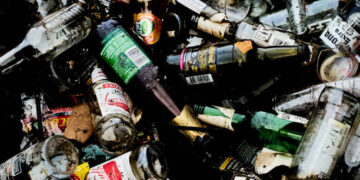 Sittingbourne, United Kingdom – November 16, 2021: A close-up top view of a pile of discarded alcoholic glass drink bottles