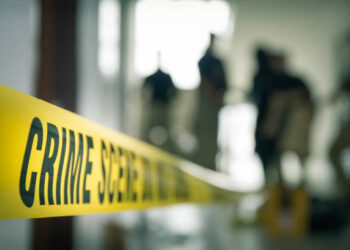 crime scene tape with blurred forensic law enforcement background in cinematic tone and copy space