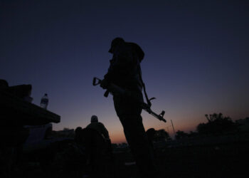 FILE - In this Feb. 9, 2014, file photo, an armed man from a self-defense group stands with his weapon at the entrance of Apatzingan in Michoacan state, Mexico. Prosecutors in western Mexico announced this Wednesday April 16, 2014 that they arrested the mayor of Apatzingan that once served as a stronghold of the Knights Templar drug cartel on charges that he helped the gang extort money from city council members. (AP Photo/Marco Ugarte, File)