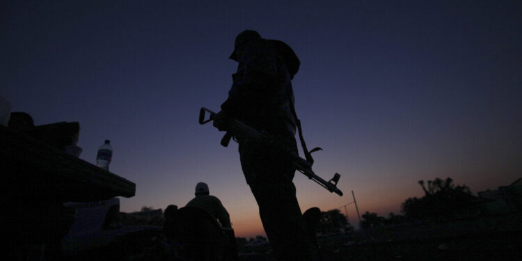 FILE - In this Feb. 9, 2014, file photo, an armed man from a self-defense group stands with his weapon at the entrance of Apatzingan in Michoacan state, Mexico. Prosecutors in western Mexico announced this Wednesday April 16, 2014 that they arrested the mayor of Apatzingan that once served as a stronghold of the Knights Templar drug cartel on charges that he helped the gang extort money from city council members. (AP Photo/Marco Ugarte, File)