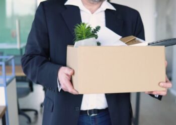 Sad dismissed senior worker are taking his office supplies with him from office. Old man is retiring. Retirement concept. Dismissal from work.