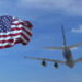 Commercial airplane landing behind waving flag