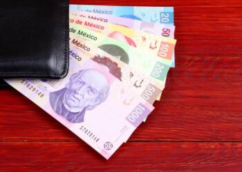 Mexican Pesos in the black wallet on a wooden background