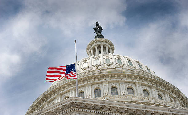 An American flag flies at half mast over U.S. Capitol Building.