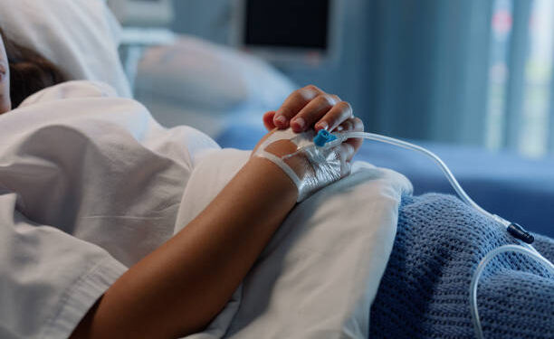 Drip, patient and hand in hospital, medical and help from IV, vitamins and medicine, blood and treatment. Bed, sick and person in clinic, healthcare and rehabilitation, saline and healing in ICU