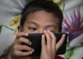 Photo taken in Bogor, Indonesia on 25 September 2016 show A child looking for internet on mobile phone. Story of Darkside of Internet cause to Children Story. Gang rape case at Bengkulu-Sumatera that killed a young girl by 14 boys is one of example tips of ice berg of mountain ice effect about Internet effect to the Sexual harrasment to child case in Indonesia.Internet Sehat Indonesia, an NGO for healthy internet in Indonesia reported that number of internet users in Indonesia from 2011-2014 increase significantly because of the infrastructure
for internet connection in Indonesia from BTS by Telecommunication company and fiber optic, in total of 252,4 Million of Indonesian people, 88,1 million using Internet and with 49% of them are age 8-25 years old. Mrs. Rita from Indonesian Child Protection of Commission (KPAI) explain that the number
of children using internet effect significantly to the number case of sexual harrasment case, in 2015 reported total 463 case of case Pornograph and cyber crime, which increase 69% from 2014 with 322 case."But this is just what we have, because sexual harrasment case is not always reportable case since the parents feel shame with it", Mrs. Rita Explain. Mrs. Neneng Handayani, chief of PSMP Handayani, a child protection house for children with law problem add that PSMP Handayani for the past 5 years receive increasing number of sex abuse case. Internet on one sid can give good information but on the other side can give bad effect on children, parents involvement are highly needed to prevent further case sex abuse by internet happening again.
(Photo by Donal Husni/NurPhoto via Getty Images)