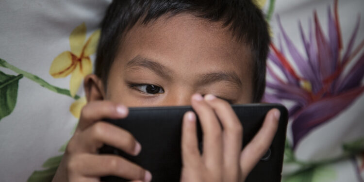 Photo taken in Bogor, Indonesia on 25 September 2016 show A child looking for internet on mobile phone. Story of Darkside of Internet cause to Children Story. Gang rape case at Bengkulu-Sumatera that killed a young girl by 14 boys is one of example tips of ice berg of mountain ice effect about Internet effect to the Sexual harrasment to child case in Indonesia.Internet Sehat Indonesia, an NGO for healthy internet in Indonesia reported that number of internet users in Indonesia from 2011-2014 increase significantly because of the infrastructure
for internet connection in Indonesia from BTS by Telecommunication company and fiber optic, in total of 252,4 Million of Indonesian people, 88,1 million using Internet and with 49% of them are age 8-25 years old. Mrs. Rita from Indonesian Child Protection of Commission (KPAI) explain that the number
of children using internet effect significantly to the number case of sexual harrasment case, in 2015 reported total 463 case of case Pornograph and cyber crime, which increase 69% from 2014 with 322 case."But this is just what we have, because sexual harrasment case is not always reportable case since the parents feel shame with it",  Mrs. Rita Explain. Mrs. Neneng Handayani, chief of PSMP Handayani, a child protection house for children with law problem add that PSMP Handayani for the past 5 years receive increasing number of sex abuse case. Internet on one sid can give good information but on the other side can give bad effect on children, parents involvement are highly needed to prevent further case sex abuse by internet happening again. 

 (Photo by Donal Husni/NurPhoto via Getty Images)