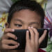 Photo taken in Bogor, Indonesia on 25 September 2016 show A child looking for internet on mobile phone. Story of Darkside of Internet cause to Children Story. Gang rape case at Bengkulu-Sumatera that killed a young girl by 14 boys is one of example tips of ice berg of mountain ice effect about Internet effect to the Sexual harrasment to child case in Indonesia.Internet Sehat Indonesia, an NGO for healthy internet in Indonesia reported that number of internet users in Indonesia from 2011-2014 increase significantly because of the infrastructure
for internet connection in Indonesia from BTS by Telecommunication company and fiber optic, in total of 252,4 Million of Indonesian people, 88,1 million using Internet and with 49% of them are age 8-25 years old. Mrs. Rita from Indonesian Child Protection of Commission (KPAI) explain that the number
of children using internet effect significantly to the number case of sexual harrasment case, in 2015 reported total 463 case of case Pornograph and cyber crime, which increase 69% from 2014 with 322 case."But this is just what we have, because sexual harrasment case is not always reportable case since the parents feel shame with it", Mrs. Rita Explain. Mrs. Neneng Handayani, chief of PSMP Handayani, a child protection house for children with law problem add that PSMP Handayani for the past 5 years receive increasing number of sex abuse case. Internet on one sid can give good information but on the other side can give bad effect on children, parents involvement are highly needed to prevent further case sex abuse by internet happening again.
(Photo by Donal Husni/NurPhoto via Getty Images)