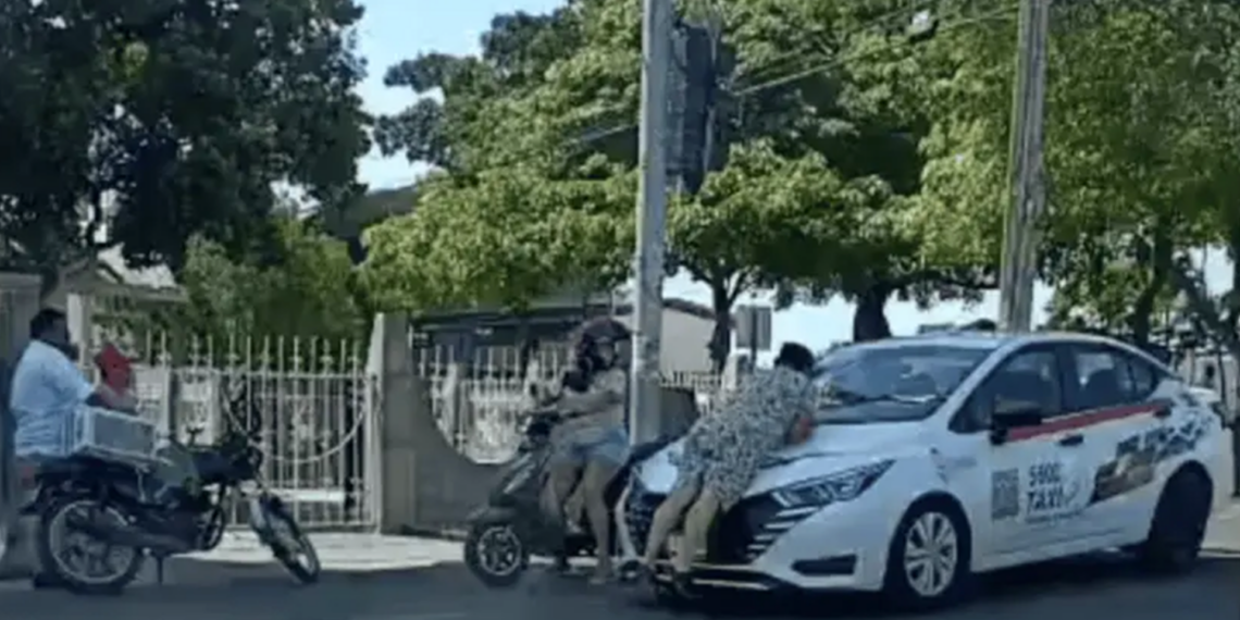 Mujer se sube al cofre de un taxi para exigir presunto pago de 12 mil pesos en Tabasco
