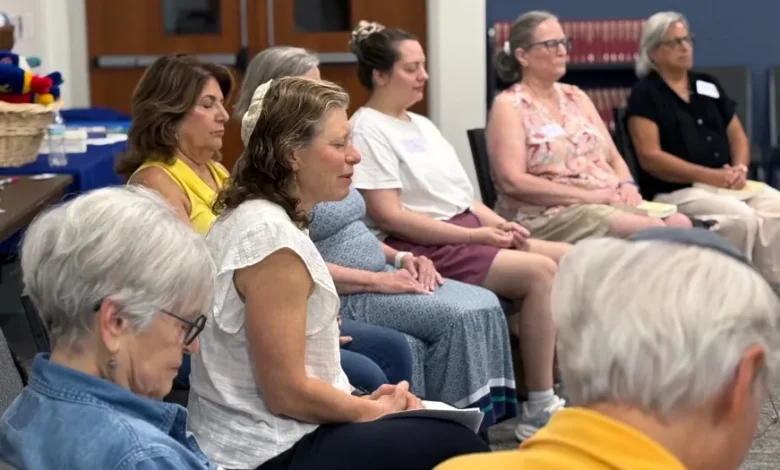 Participantes realizan una práctica de meditación judía durante una actividad religiosa
