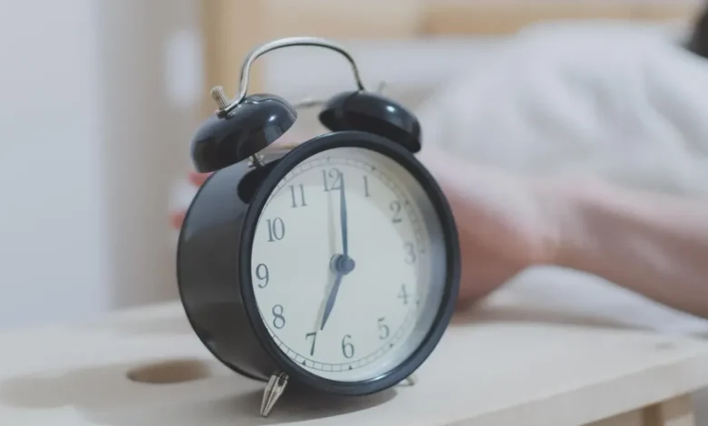 Persona despertando antes de que suene la alarma de su teléfono celular