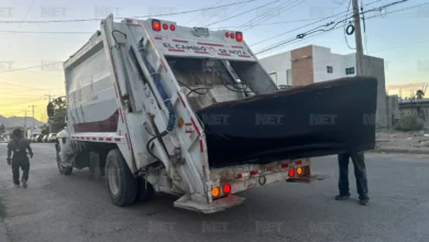 Sillón introducido en un camión recolector de basura en la colonia Lomas del Rey de Ciudad Juárez