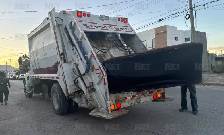 Sillón introducido en un camión recolector de basura en la colonia Lomas del Rey de Ciudad Juárez
